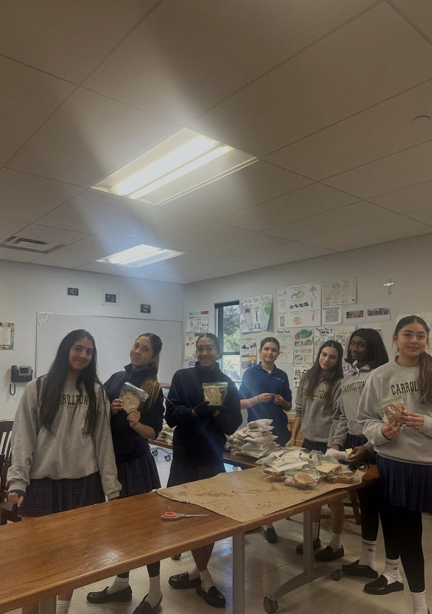 Students holding up bagged sandwiches